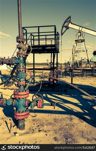 Valves armature of an oil well mouth. Oil and gas industry theme. Petroleum concept. Russia, Sibirea.. Oil wellhead with valve armature. Oil and gas industry theme. Petroleum concept.