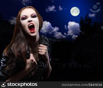 Vampire girl on night sky background