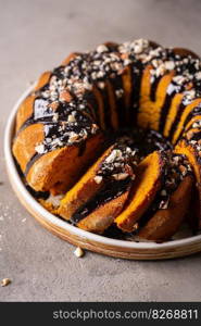 Vanilla bundt cake with chocolate glaze and nuts on top. Vanilla bundt cake