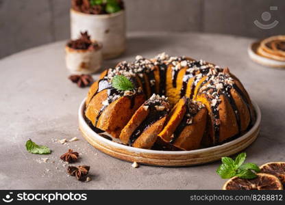 Vanilla bundt cake with chocolate glaze and nuts on top. Vanilla bundt cake