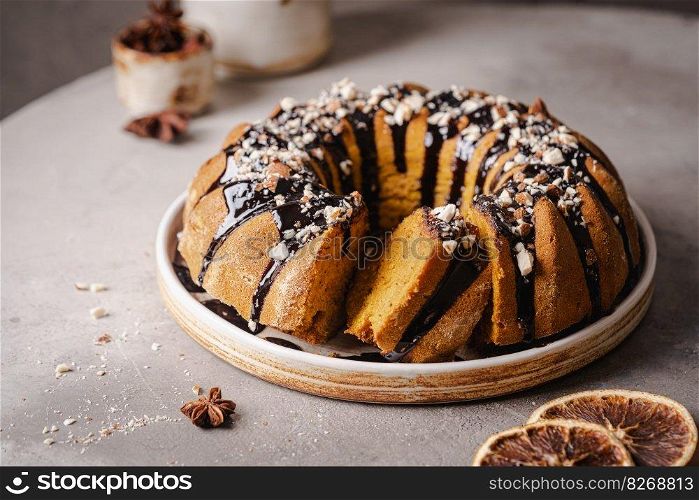 Vanilla bundt cake with chocolate glaze and nuts on top. Vanilla bundt cake