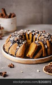 Vanilla bundt cake with chocolate glaze and nuts on top. Vanilla bundt cake