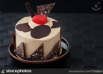 Vanilla cake with cherries on wooden background in low light, AF point selection, copy space for write.