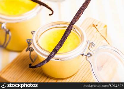 Vanilla custard in little jars on the table, sweet dessert
