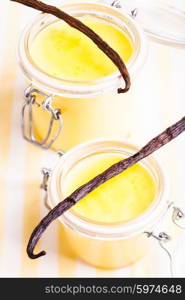 Vanilla custard in little jars on the table, sweet dessert