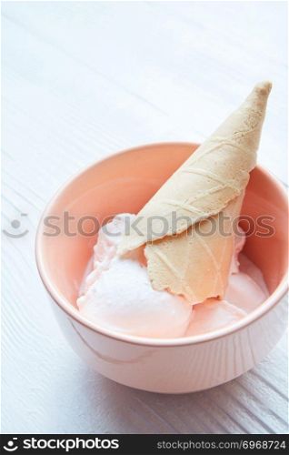 Vanilla ice cream in a plate with a waffle cone close-up isolated on a white background. Vanilla ice cream in a plate