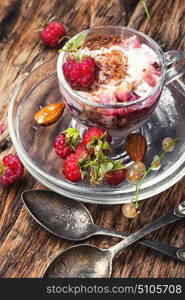 vanilla ice cream with raspberry. Raspberry ice cream with currants in glass cup.Sundae on vintage rustic background.