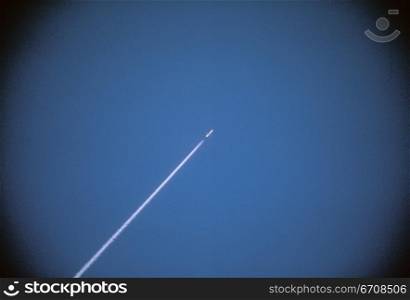 Vapor trail of a rocket against blue sky