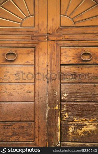 varese abstract rusty brass brown knocker in a closed wood door vedano olona italy