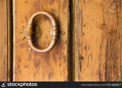 varese abstract rusty brass brown knocker in a closed wood door venegono italy