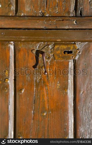 varese sumirago abstract rusty brass brown knocker in a door curch closed wood lombardy italy