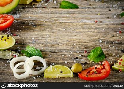 Varied cut vegetables and spices on wooden table. Top view. Copy space.