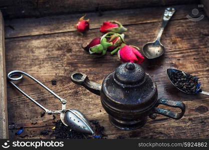 Varieties of dry tea. Dried tea leaves in spoons on stylish background of the teapot.