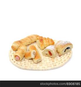 variety assortment of baked filled pastry on wicker rattan coaster isolated over white background