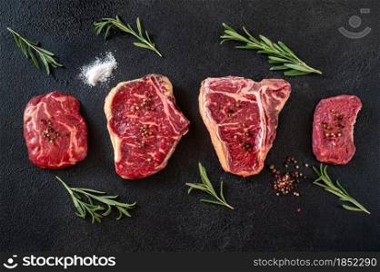 Variety of beef steaks on dark background