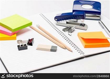 Variety of business office supplies on white notepad