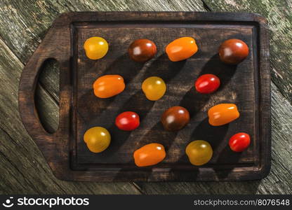 Variety of cherry tomatoes on wood. Multicolored tomatoes