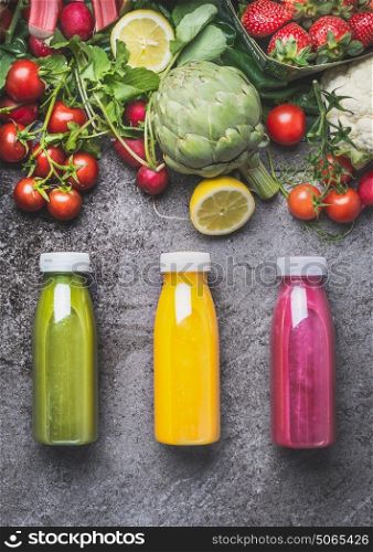 Variety of colorful Smoothies or juices beverages drinks in bottles with fresh ingredients: fruits ,berries and vegetables on gray concrete background , top view. Healthy Food concept