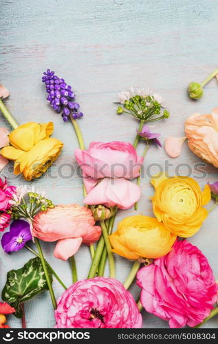 Variety of colorful summer flowers for greeting bouquet on blue vintage shabby chic background, top view, copy space