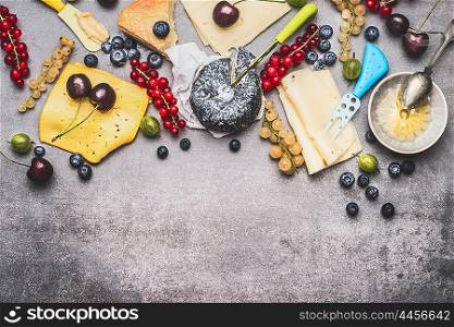 Variety of Delicious cheese with berries and honey for dessert or Breakfast on rustic background, top view, border