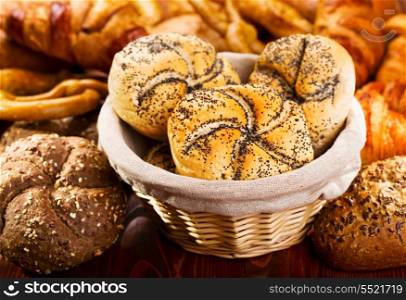 Variety of fresh bread and pastry on wooden table