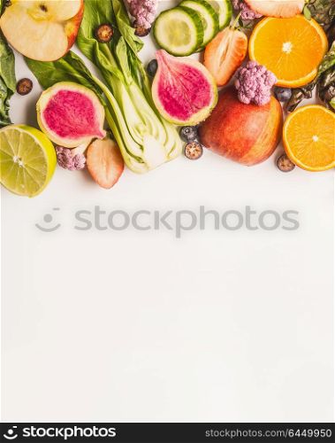 Variety of fresh colorful fruits, citrus and vegetables on white background, top view, border. Healthy food and clean eating ingredients concept