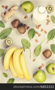 Variety of fresh fruits and nuts for healthy eating or making green smoothie over light grey background, top view. Healthy eating, vitamin, detox, diet food, clean eating concept