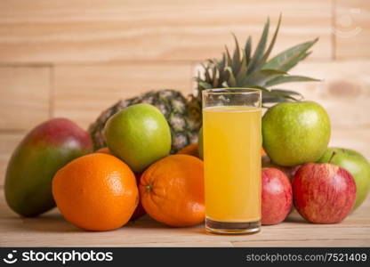 variety of fruits and orange juice on a wooden table, studio picture