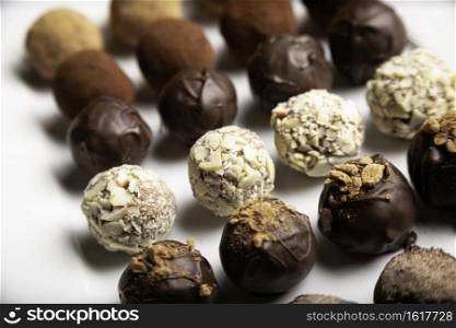 variety of handmade gourmet chocolate truffle candy on a white plate