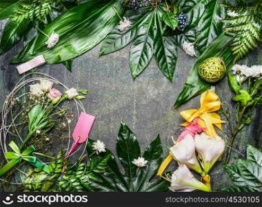 variety of light flowers and green leaves with decoration arrangement to create greeting bouquet on rustic background, top view, frame
