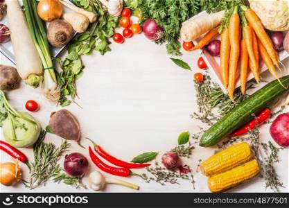 Variety of organic vegetables for tasty vegan or vegetarian cooking on white wooden background, top view, frame. Healthy or diet food concept
