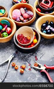 Variety of shapes and colors beads to make a bead necklace.Jewelry making and beading. Colorful beads in wooden bowls