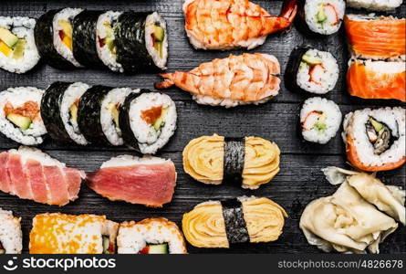 Variety of sushi: maki, nigiri,rolls on dark wooden background, top view