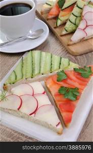 variety of vegetable sandwiches on a table with cup of coffee