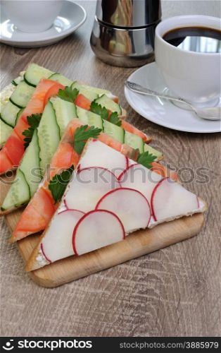 variety of vegetable sandwiches on a table with cup of coffee