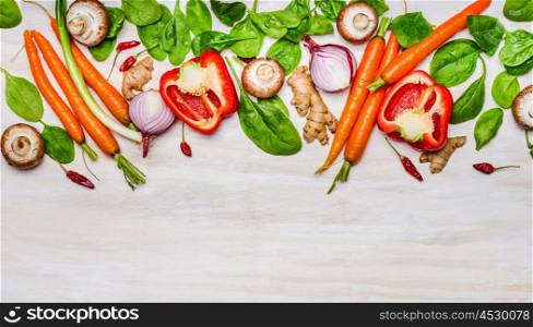 variety of vegetables ingredients for healthy eating and cooking on white wooden background, top view, border. Vegetarian or diet food concept.