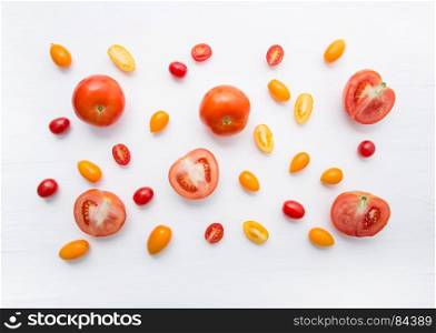 variety tomatoes on white wooden background.