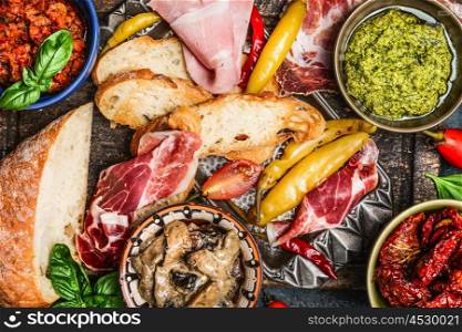 various antipasti, ciabatta bread, pesto and ham , top view, close up