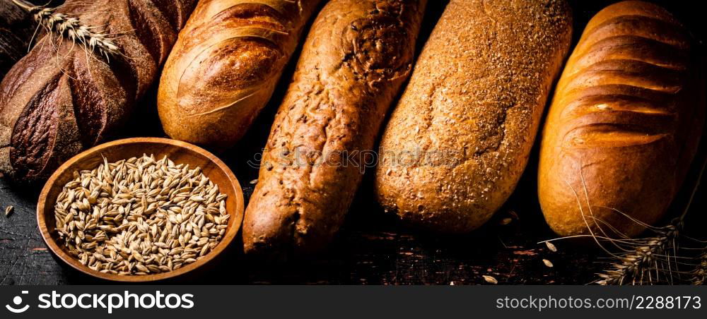 Various bread with grain in a bowl on the table. Against a dark background. High quality photo. Various bread with grain in a bowl on the table.