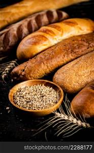 Various bread with grain in a bowl on the table. Against a dark background. High quality photo. Various bread with grain in a bowl on the table.