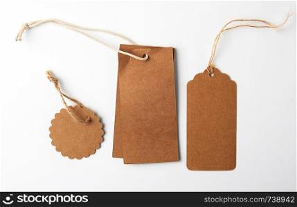 various brown paper tags with ropes on white background, business concept