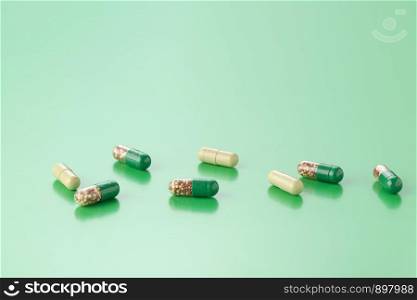 various capsules with antibiotics on a colored background. various capsules with antibiotics on a green background