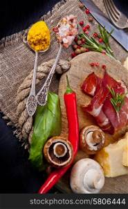 Various cheeses, salami and mushrooms on the wooden board