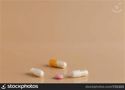 Various color pills and capsules. Various color pills and capsules on beige background