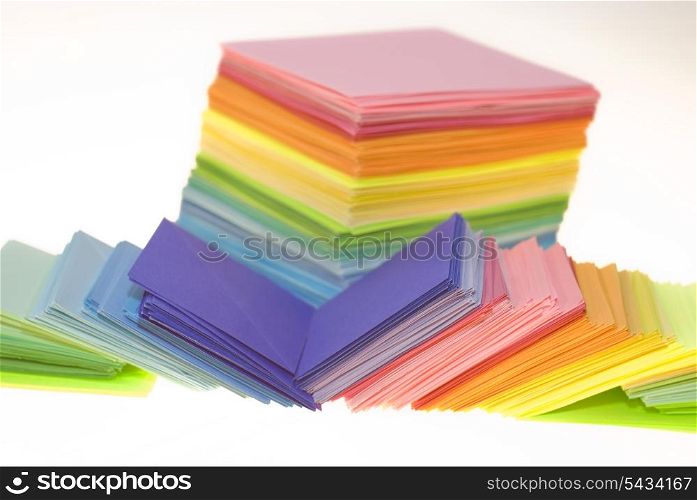 Various color shits of paper scattered on white background