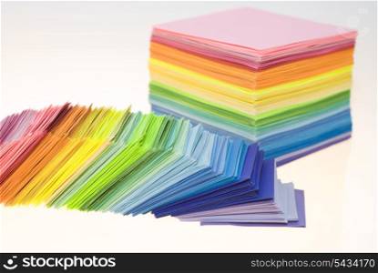 Various color shits of paper scattered on white background