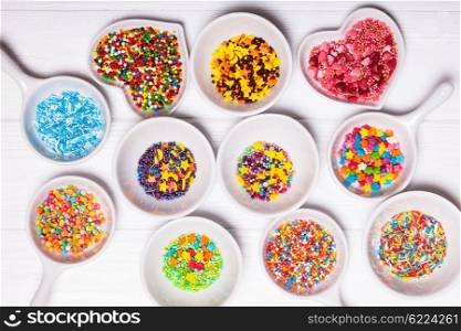 Various color sprinkles in a white bowls. The color sprinkles
