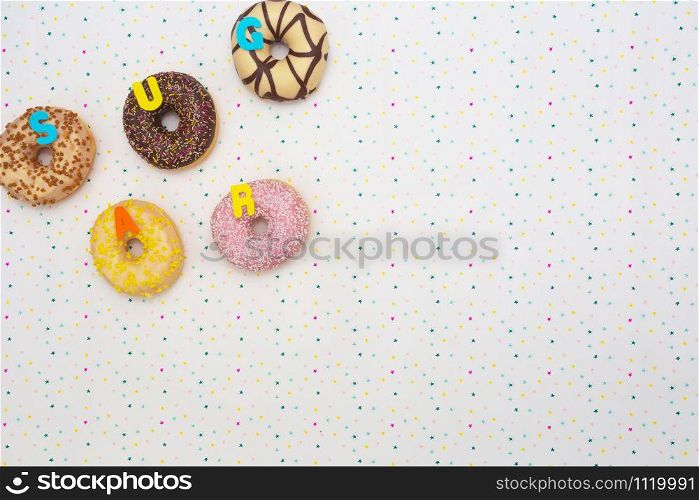 Various colored delicious donuts with festive star background Celebration concept. Top view space for text background party concept. Various colored delicious donuts with festive star background Celebration concept. Top view space for text background