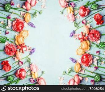 Various colorful garden flowers in summer color on blue turquoise shabby chic background, floral frame, top view, vertical