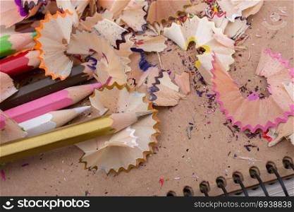 Various colorful pencil shavings laying around on a notebook